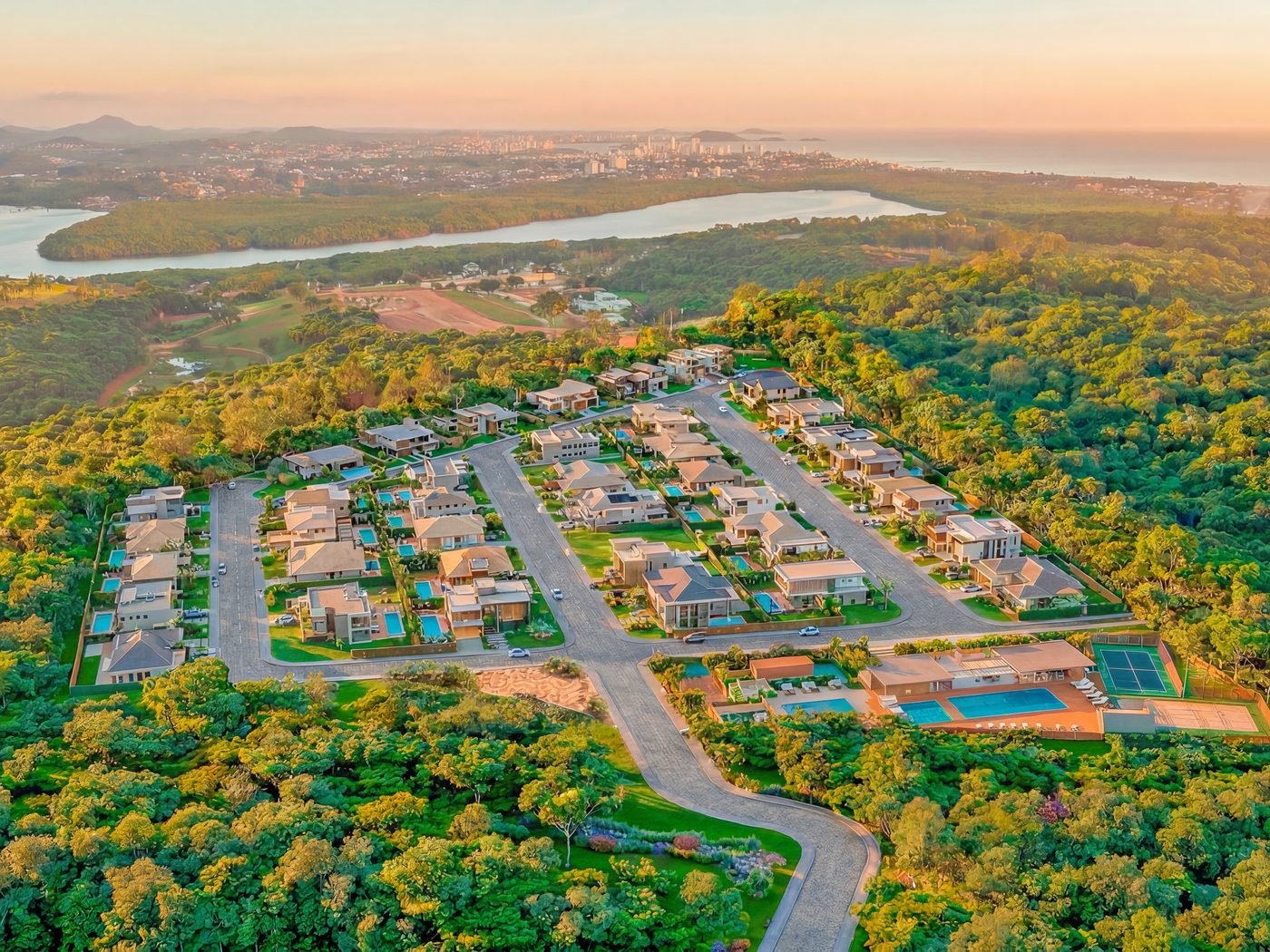 Vista aérea humanizada do condomínio com a lagoa e o mar ao fundo